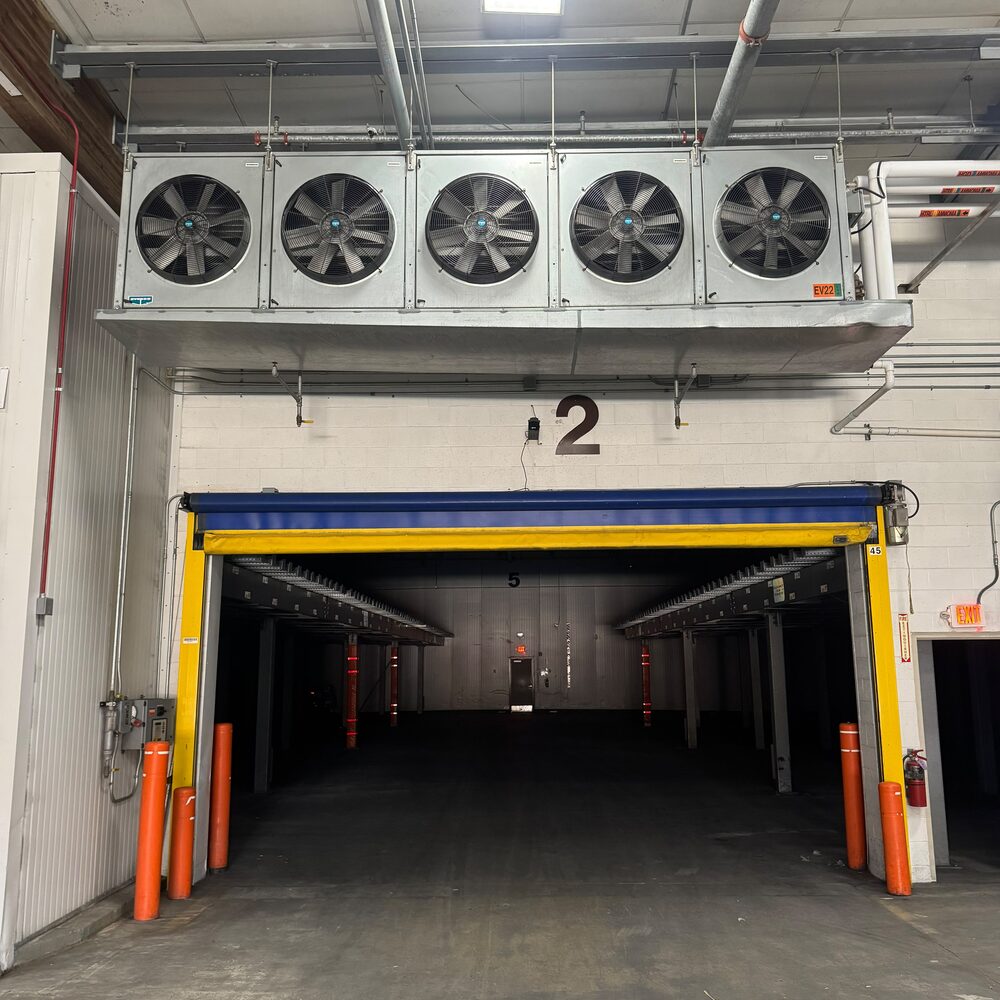 Five-fan evaporator unit powered above a cold storage dock door